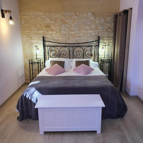 - une chambre avec un grand lit noir et des oreillers roses dans l'établissement Gîte de 9 personnes avec piscine, à Salviac