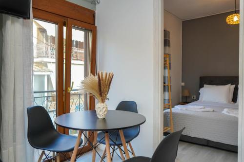 una stanza con un tavolo, sedie e un letto di Bougainvillea Loft a Párga