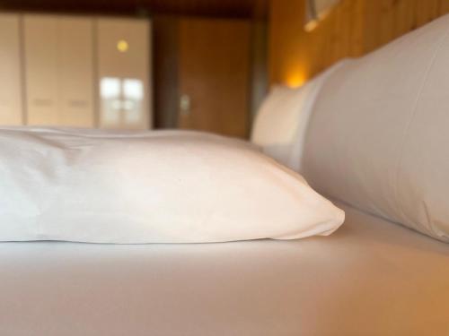 a white pillow sitting on top of a bed at Swiss Apartment Thunersee in Einigen