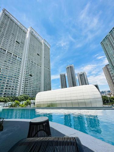 a swimming pool in a city with tall buildings at Novotel Manila Residence Hotel by Jolly Luxe Suites at Acqua in Manila