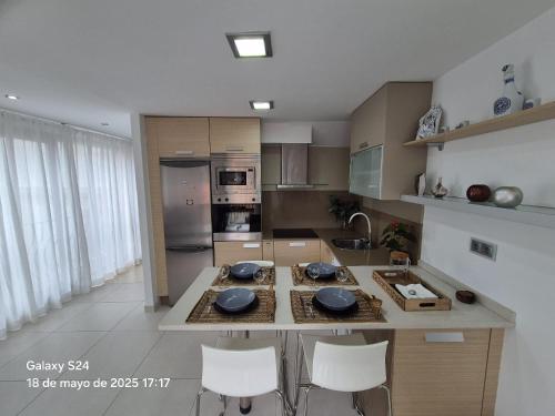 a kitchen with a table and chairs in a room at Lar BCN in Pobra do Caramiñal