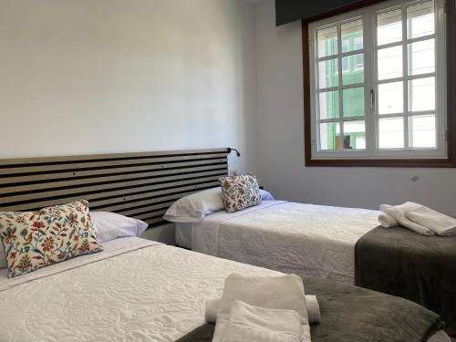 a bedroom with two beds and a window at A un Paso in Caldas de Reis