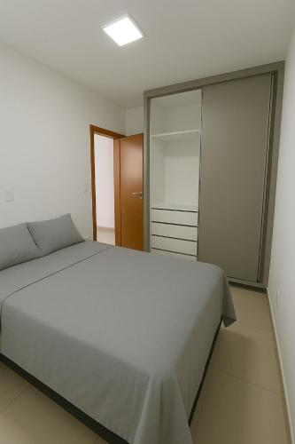 a bedroom with a large bed and a closet at Apto Novo com Ar e Wi-Fi Perto da UFU Monte Carmelo in Monte Carmelo