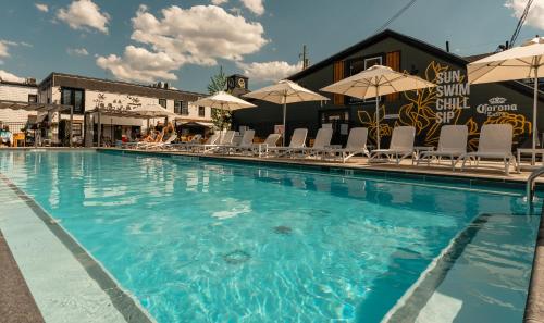 a large swimming pool with chairs and umbrellas at Colonial Hotel & Suites in Grand Bend
