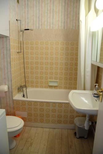 une salle de bain avec une baignoire, des toilettes et un lavabo dans l'établissement Le Vintage By Tranquil at Home, à Pornichet