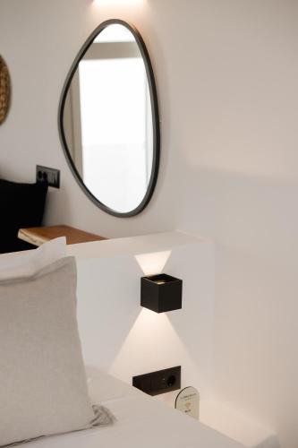 a bedroom with a mirror and a bed at Commercio Suites Santorini in Emporio Santorini
