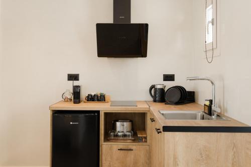 a kitchen with a black refrigerator and a sink at Commercio Suites Santorini in Emporio Santorini
