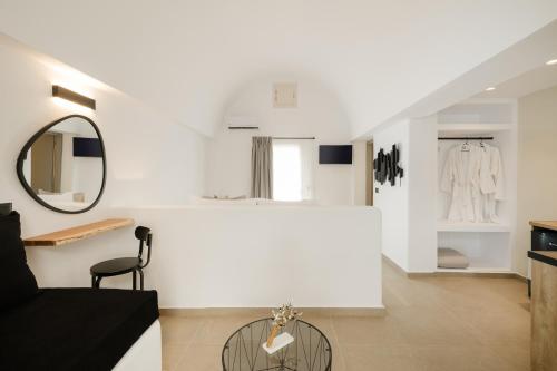 a white room with a chair and a mirror at Commercio Suites Santorini in Emporio Santorini