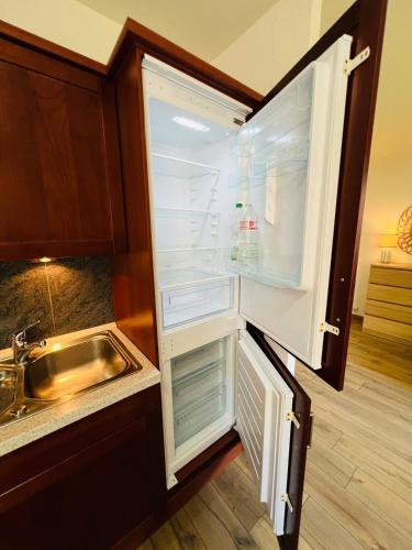 - un réfrigérateur vide avec une porte ouverte à côté d'un évier dans l'établissement Modern Loft Basel Airport ArtBasel, à Saint-Louis