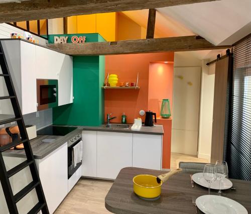 - une cuisine avec une mezzanine et une table dans l'établissement Le Refuge Saint Sauveur, à Caen