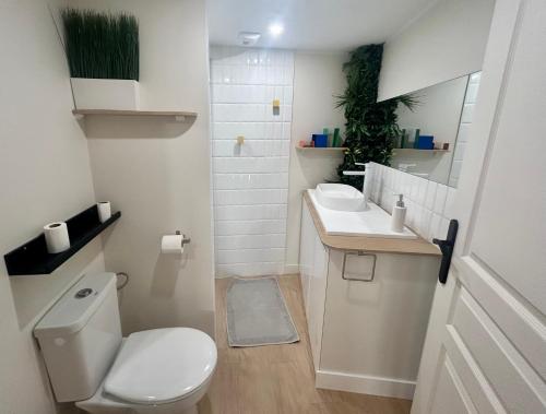 une salle de bain blanche avec des toilettes et un lavabo dans l'établissement Le Refuge Saint Sauveur, à Caen