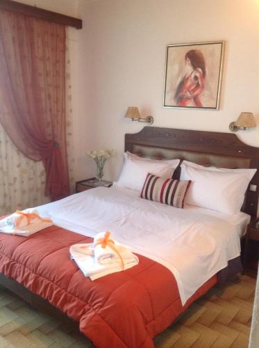 a bedroom with a large bed with towels on it at Angela Hotel in Agia Marina Aegina