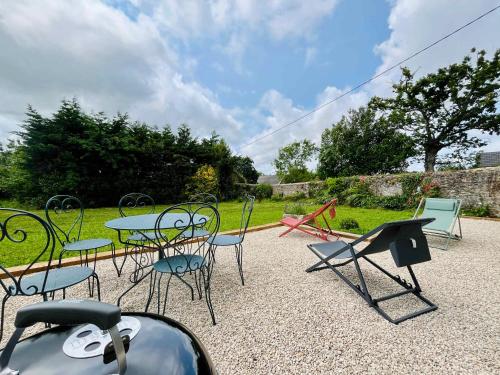 a group of chairs and tables in a yard at Le Clos du Haut Gallion An authentic haven of peace 
