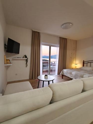 ein Wohnzimmer mit einer Couch und einem Bett in der Unterkunft Apartments Miljas in Cavtat