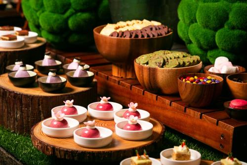 a display of cakes and pastries on a table at Regent Chongqing - Complimentary 1st round mini bar daily in Chongqing