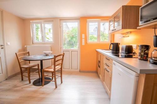 une cuisine avec une table et des chaises dans une pièce dans l'établissement Gite Maisonnette avec terrasse - hyper centre Amboise, à Amboise