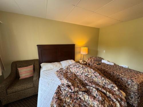 a bedroom with two beds and a couch and a lamp at Pioneer Inn by the River in Port Hardy