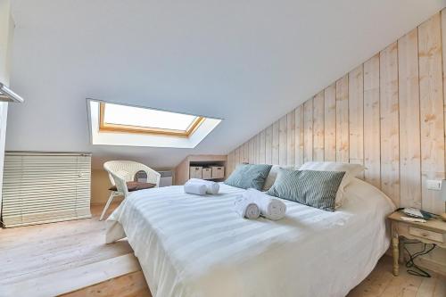 une chambre avec un grand lit blanc avec des serviettes dessus dans l'établissement Ancora4 - Appartement avec vue mer et garage, à La Chaume