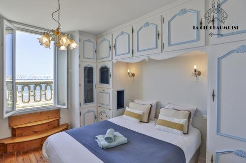 - une chambre dotée d'un grand lit blanc avec des draps bleus dans l'établissement Villa des Palmiers, à Les Sables-dʼOlonne