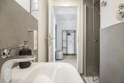 a white bathroom with a sink and a shower at Ferienwohnung Nordseeheimat Pellworm in Pellworm
