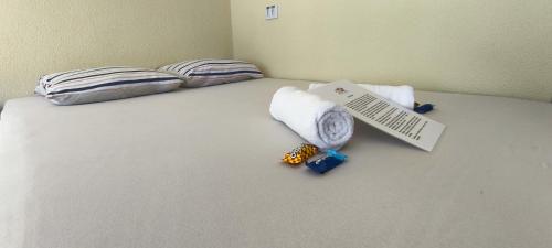 a bed with some pillows and a sign on it at Chalé Completo Com Linda Vista para o Mar de Ilhabela 2 in Ilhabela