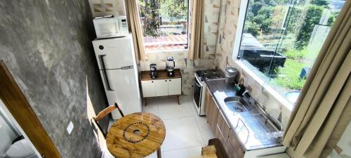 a small kitchen with a sink and a refrigerator at Chalé Completo Com Linda Vista para o Mar de Ilhabela 2 in Ilhabela