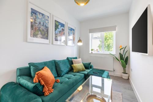 プラムステッドにあるStylish 2 x Double Bed Apt in Woolwich Londonのリビングルーム(緑のソファ、ガラスのテーブル付)