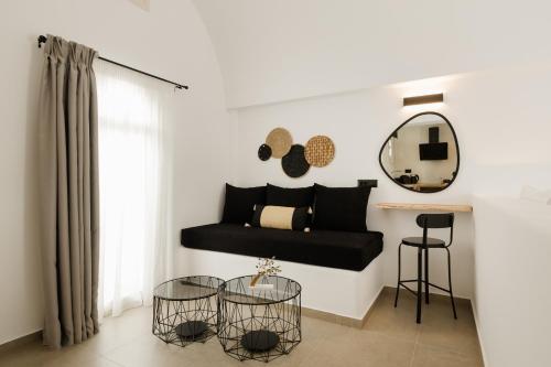 a living room with a black couch and a mirror at Commercio Suites Santorini in Emporio Santorini
