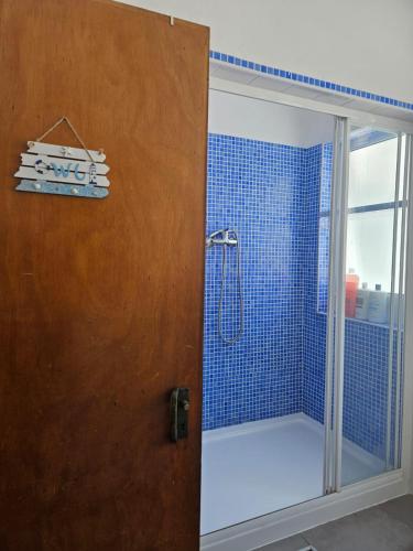 a bathroom with a shower with blue tiles at Lagos Haven Guesthouse in Lagos