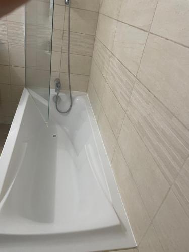 La salle de bains est pourvue d'une cabine de douche et d'une baignoire blanche. dans l'établissement Chambre double lit King size, à La Celle-sous-Gouzon