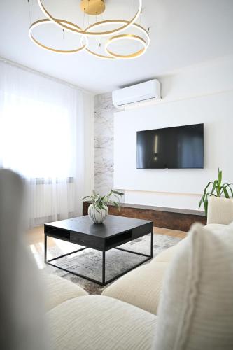 a living room with a coffee table and a tv at Luxury Apartment Antoni in Podstrana