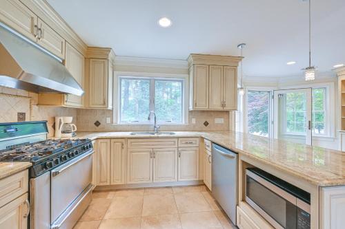 a kitchen with wooden cabinets and a stove top oven at Private Pool and Patio Luxe Westchester Home! in Briarcliff Manor