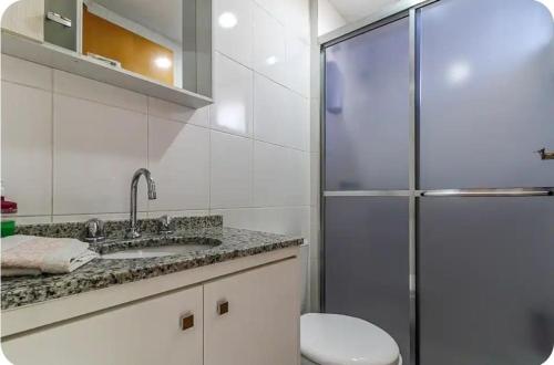 y baño con lavabo y nevera. en Prédio Central, en Curitiba