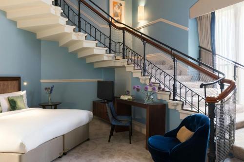 a bedroom with a staircase with a bed and a desk at St Pancras London, Autograph Collection in London
