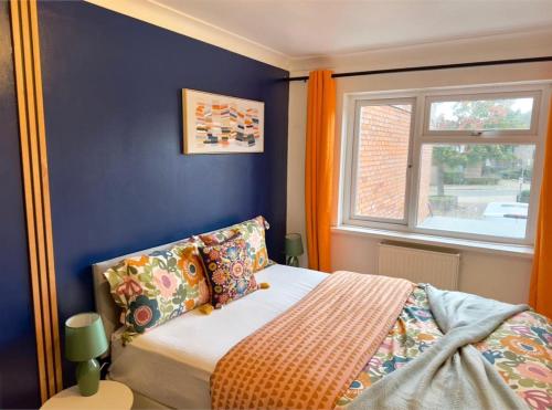 a bedroom with a bed with blue walls and a window at Kaly- Relaxing Garden, Central, Close Parking, near Portsmouth Harbour Train Station, Gunwharf Quays, Southsea in Portsmouth