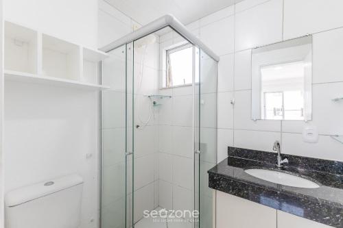 ein Badezimmer mit Glasdusche und Waschbecken in der Unterkunft Belo apartamento a menos de 2 min do mar VJG0102 in Cururupe