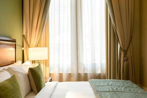 a bedroom with a bed and a large window at St Pancras London, Autograph Collection in London
