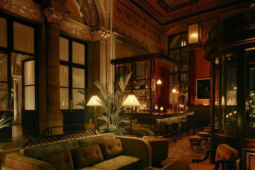 a living room with a couch and a bar at St Pancras London, Autograph Collection in London