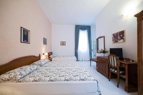 1 dormitorio con 2 camas, escritorio y TV en B&B Porta di Mare en Catanzaro