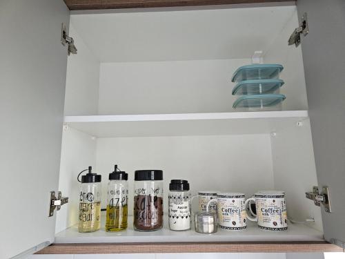 a cupboard filled with lots of bottles and dishes at Apartamento inteiro, ar-condicionado e vaga de garagem in Paranaguá