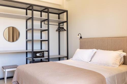 a bedroom with a bed and a black book shelf at Alkida Luxury Rooms Tolo in Tolo