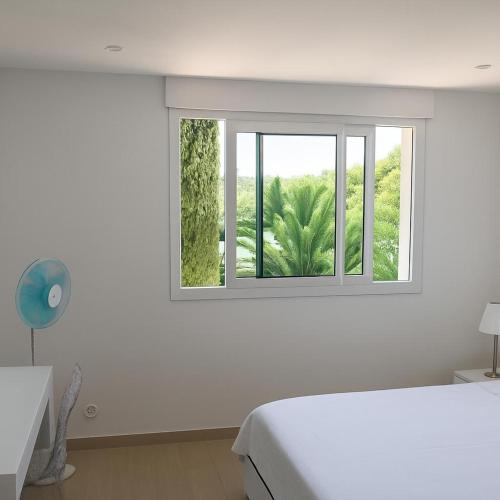 une chambre blanche avec un lit et une fenêtre dans l'établissement Studio in Saint tropez, swimming pool and parking, à Saint-Tropez