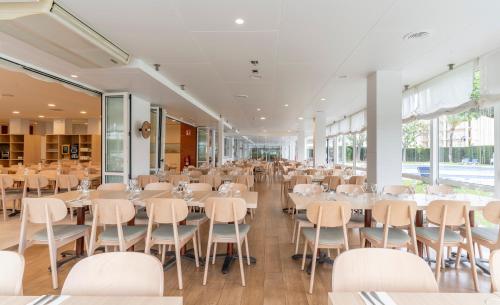 a banquet hall with tables and chairs in a building at Prestige Goya Park in Roses