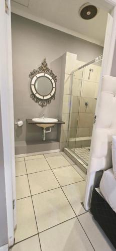 a bathroom with a sink and a mirror at GALAXY BOSTON BELLVILLE in Cape Town