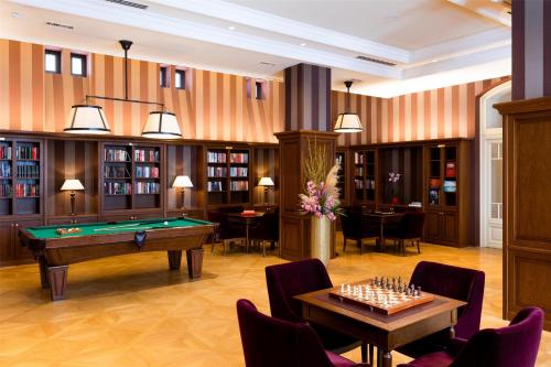 a billiard room with a pool table and books at Grand Hotel Kempinski High Tatras in Štrbské Pleso
