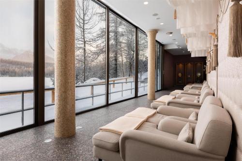 a row of chairs in a room with large windows at Grand Hotel Kempinski High Tatras in Štrbské Pleso