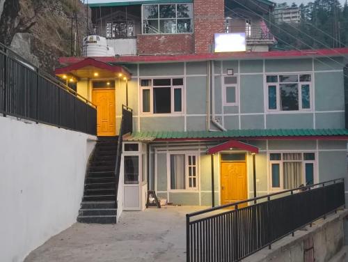 a house with yellow doors and a stairway at Fair lawns Home Stay in Shimla