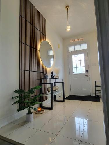 a hallway with a table and a mirror and a door at Beautiful Family Suites - Master Bedroom in Niagara Falls