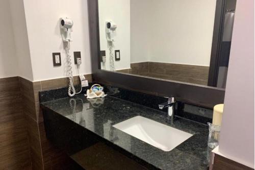 a bathroom with a sink and a phone at Beverly Hills: Hotel and Business in San Salvador