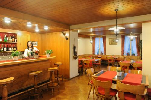 a restaurant with a woman standing at the bar at Hotel Beausite in Interlaken
